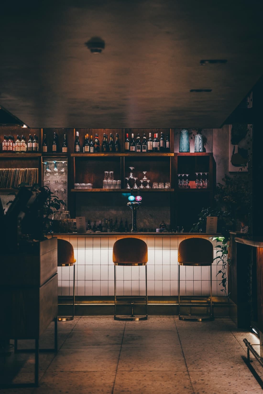 Ambiance tamisée du Kraken Bar : lumières basses et bouteilles.
