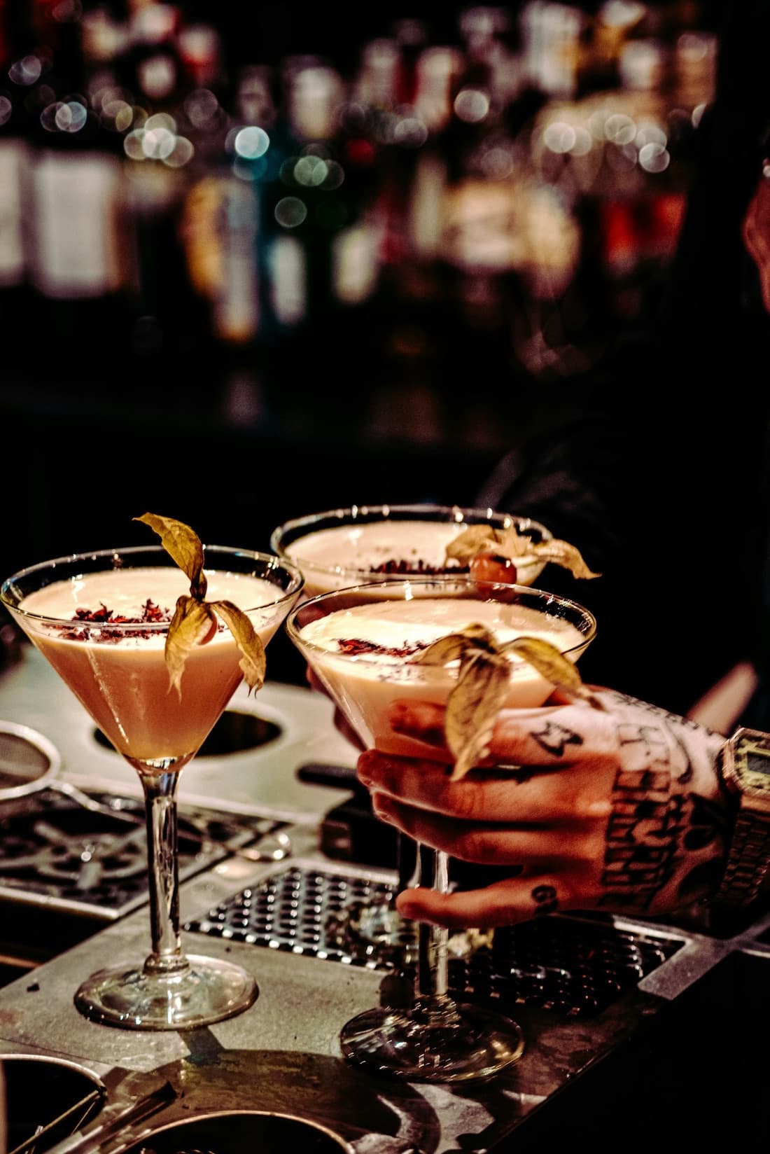 Trois cocktails maison dressés au comptoir par le barman du Kraken.