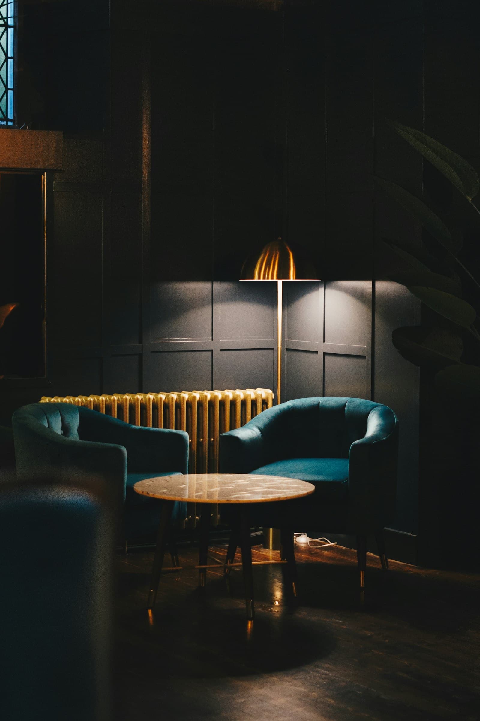Salon tamisé du Kraken Bar : velours profond, lumière chaude et ambiance feutrée.